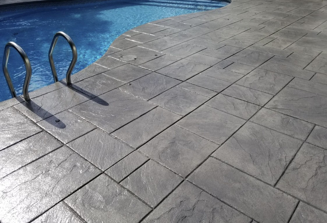 Stamped concrete patio by pool in Alexandria, VA
